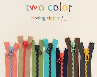 Puede incluir: Surtido de cremalleras de costura de dos tonos en varios colores, incluidos azul, verde, naranja, marrón y negro. Las cremalleras tienen un color contrastante en cada lado. El texto "two color sewing zipper!" está escrito encima de las cremalleras.