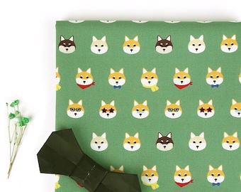 May include: Green fabric with a repeating pattern of Shiba Inu dog faces. The dogs are wearing different accessories, including sunglasses, scarves, and bandanas. A dark green bow tie is in the foreground.