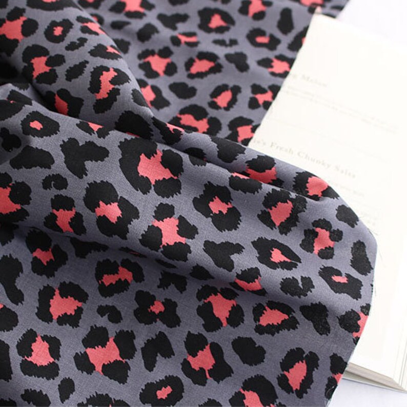 May include: Gray and pink leopard print fabric with a soft, smooth texture.