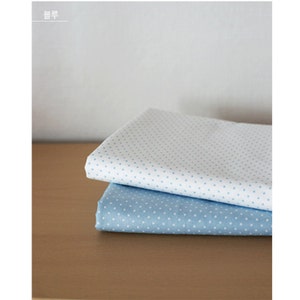 May include: Two folded pieces of fabric stacked on top of each other. The top piece is white with small light blue polka dots, and the bottom piece is light blue with small white polka dots. The text "블루" is visible in the top left corner.