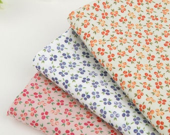 May include: Three fabric swatches with different floral patterns. The top swatch is light green with small orange flowers. The middle swatch is white with small blue flowers. The bottom swatch is pink with small red flowers.