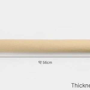 K&ouml;nnte beinhalten: Ein beigefarbener, aufgerollter Stoff, der etwa 142 cm lang ist. Der Stoff ist 1,2 mm dick.