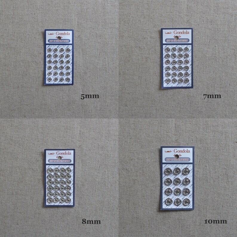 May include: Four packs of silver metal snap fasteners in different sizes: 5mm, 7mm, 8mm, and 10mm. Each pack has a white label with the brand name "Gondola" and the size of the fasteners printed on it.