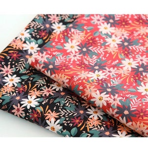 May include: Two fabric swatches with a floral pattern. One swatch is black with white, pink, and green flowers. The other swatch is red with white, pink, and green flowers.