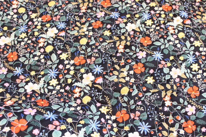 Pu&ograve; includere: Un tessuto nero caratterizzato da un motivo denso e ripetitivo di piccoli fiori nelle tonalit&agrave; dell'arancione, giallo, azzurro e rosa, intervallati da foglie verdi e sottili steli bianchi intrecciati che creano un design botanico continuo.