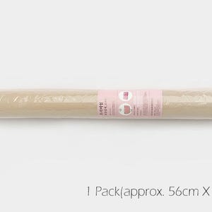 K&ouml;nnte beinhalten: Eine Rolle beigefarbene Bastelpapier, in Klarsichtfolie verpackt, mit einem rosa Etikett mit der Aufschrift "1 Pack (ca. 56 cm x 90 cm)".