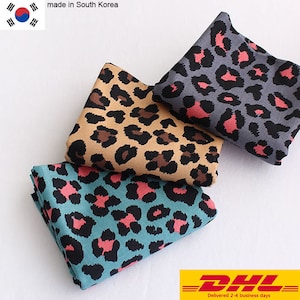 May include: Three fabric swatches with a leopard print pattern. The swatches are in teal, brown, and gray with pink accents.