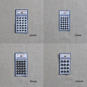 May include: Four packs of black metal snap fasteners in different sizes: 5mm, 7mm, 8mm, and 10mm. Each pack has a white label with the text "Gondola" and "Snap Fasteners".