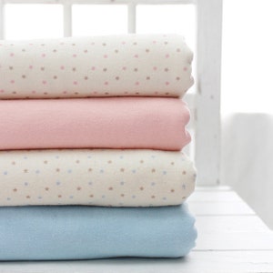 May include: A stack of four fabric swatches. The top swatch is white with a small pink star pattern. The second swatch is pink. The third swatch is white with a small blue star pattern. The bottom swatch is light blue.