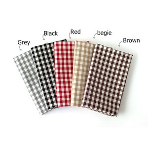 May include: Five folded fabric squares in grey, black, red, beige, and brown, each with a classic gingham check pattern. The colors are labeled above each fabric square. The fabrics are arranged in a fan shape.