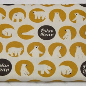 May include: White fabric with a repeating pattern of yellow circles containing polar bears in various poses. The text "Polar Bear" is printed in brown on a black circle.