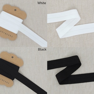 Puede incluir: Dos carretes de elástico, uno blanco y uno negro, con el nombre de la marca "PPYBEARS" impreso en los carretes.