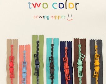 Puede incluir: Surtido de cremalleras de costura de dos tonos en varios colores, incluyendo beige, coral, verde, turquesa, azul marino, marrón y gris. Las cremalleras tienen un deslizador de metal y están etiquetadas "two color sewing zipper!"