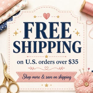 K&ouml;nnte beinhalten: Ein cremefarbenes Schild mit gewelltem Rand zeigt den dunkelblauen Text FREE SHIPPING on U.S. orders over $35 und Shop more & save on shipping. Das Schild ist mit kleinen goldenen Sternen, einem rosa gestickten Herz und Stoffen verziert.