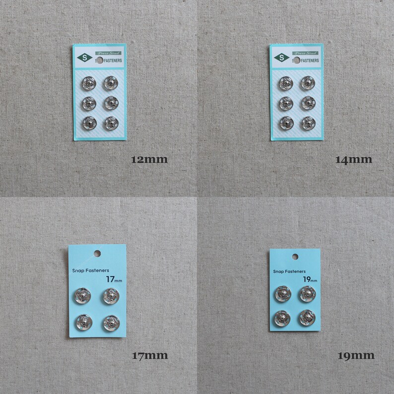 May include: Four packs of silver snap fasteners in different sizes: 12mm, 14mm, 17mm, and 19mm. Each pack has a blue label with the text "Snap Fasteners" and the size of the fasteners in millimetres.