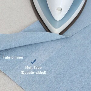 May include: A close-up of a light blue fabric with an iron on top. The text "Fabric Inner" is visible on the left side of the fabric. Below the text is a checkmark and the text "Melt Tape (Double-sided)".