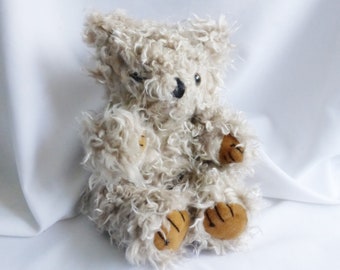 May include: A fluffy white teddy bear with brown paw pads sits on a white background. The bear has a black nose and small black eyes.
