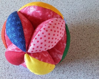 colorful gripping ball in pink with rattle, motorikball