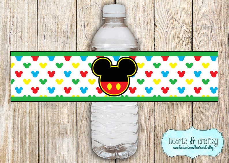 May include: Water bottle label featuring a Mickey Mouse head with red and black accents. The background is white with a repeating pattern of red, yellow, blue, and green Mickey Mouse ears.
