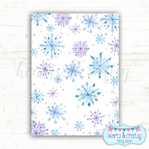Puede incluir: Un papel digital imprimible con un fondo blanco y un patr&oacute;n repetitivo de copos de nieve acuarela azules y morados. Los copos de nieve est&aacute;n dispersos aleatoriamente por la p&aacute;gina. Tambi&eacute;n hay peque&ntilde;os puntos de purpurina plateados dispersos por todo el dise&ntilde;o. El texto "Hearts & Crafty Party Decor" est&aacute; en la parte inferior de la p&aacute;gina.