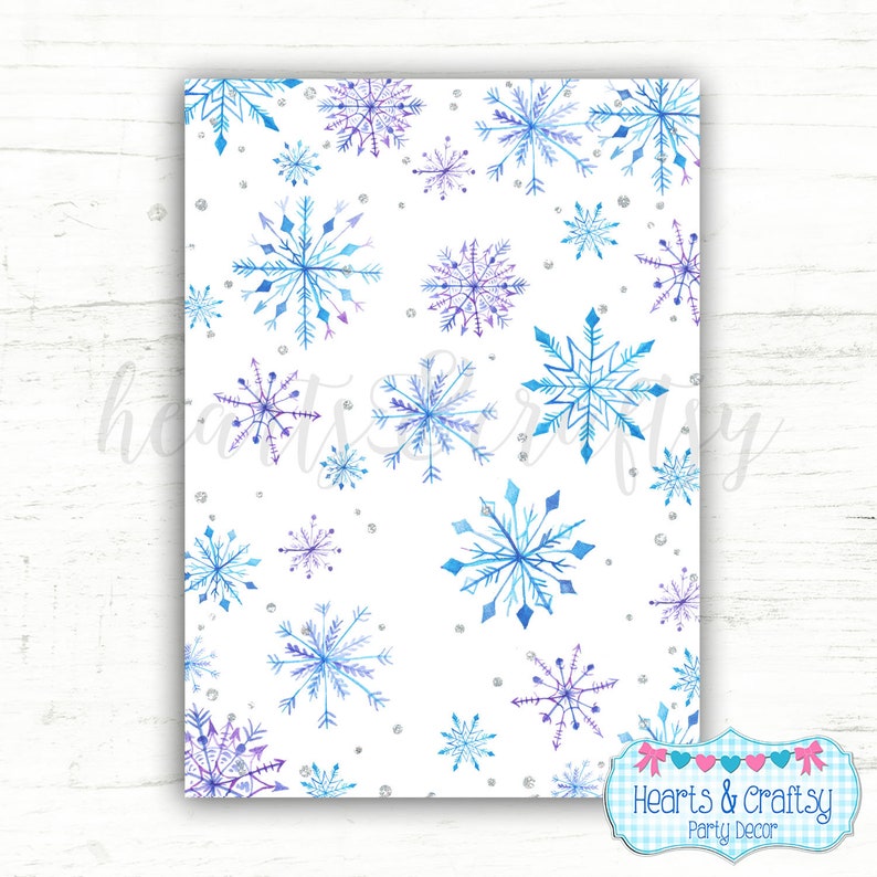 Puede incluir: Un papel digital imprimible con un fondo blanco y un patr&oacute;n repetitivo de copos de nieve acuarela azules y morados. Los copos de nieve est&aacute;n dispersos aleatoriamente por la p&aacute;gina. Tambi&eacute;n hay peque&ntilde;os puntos de purpurina plateados dispersos por todo el dise&ntilde;o. El texto "Hearts & Crafty Party Decor" est&aacute; en la parte inferior de la p&aacute;gina.