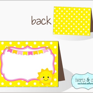 Pu&ograve; includere: Segnaposto stampabile a pois gialli e bianchi con uno striscione rosa e giallo e un sole sorridente. Il testo "hearts & crafty" &egrave; in fondo alla carta.