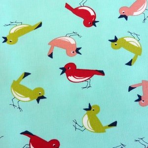 Op de afbeelding: Een turquoise stof met een herhalend patroon van kleurrijke vogels. De vogels zijn in verschillende poses, sommige vliegen, sommige zitten en sommige zingen. De vogels zijn rood, roze en groen.