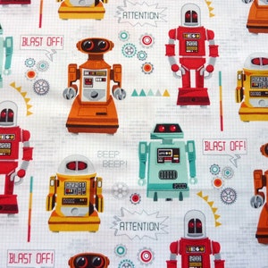 Peut inclure: Tissu blanc orné d'un motif répété de robots colorés. Les robots sont rouges, oranges, jaunes et turquoise, avec des détails comme des écrans et des antennes. Des bulles de texte indiquent "BLAST OFF!" et "ATTENTION".