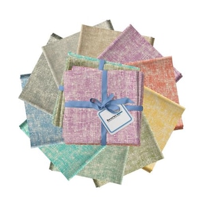 May include: A stack of square fabric swatches arranged in a circular fan pattern. The fabric features a cross-hatched texture in various colors including purple, orange, yellow, green, blue, and beige. A light blue ribbon ties the stack together.