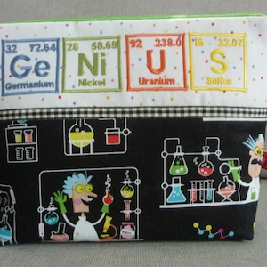 Può includere: Una pochette nera con cerniera e bordino in tessuto a scacchi bianco e nero. La parte anteriore della pochette presenta un tema scientifico con uno scienziato dei cartoni animati e becher. La parte superiore della pochette è in tessuto bianco con quadrati ricamati colorati che compongono la parola "GENIUS" usando i simboli chimici di Germanio, Nickel, Uranio e Zolfo.