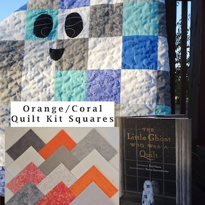 May include: A patchwork quilt with a ghost face design in shades of blue, gray, and white. The image also shows a selection of orange and coral quilt kit squares and a book titled "The Little Ghost Who Was a Quilt."
