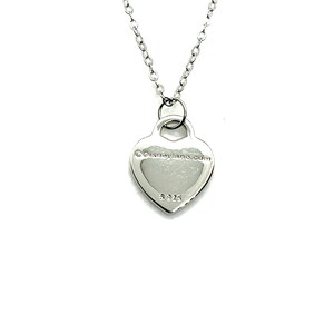 May include: Silver heart pendant necklace with a chain. The back of the pendant has the text "&copy;Disneyland.com" and the number "925".