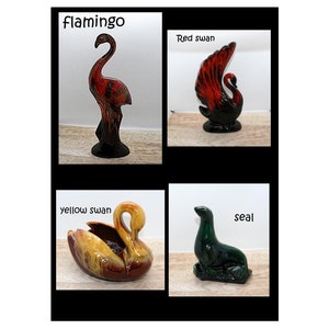 May include: A collection of four ceramic animal figurines labeled flamingo, red swan, yellow swan, and seal. The flamingo is red and black, the red swan features red and black tones, the yellow swan is yellow and brown, and the seal is green.
