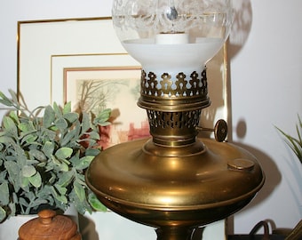 Antieke geëlektrificeerde messing olielamp uit 1914 met sierlijke glazen schoorsteen, landelijke tafellamp, vintage rustieke woondecoratie