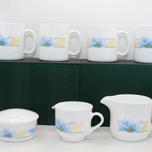 Juego vintage de 6 tazas y 2 jarrones para crema de vidrio opalino templado con diseño Flo de Arcopal France, estilo años 80. Taza con estampado floral en tonos pastel, decoración retro estilo cottagecore.