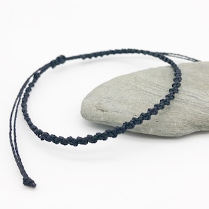 Puede incluir: Un collar de cord&oacute;n trenzado negro con un cierre simple de nudo. El collar est&aacute; hecho de cord&oacute;n fino y mide aproximadamente 45 cm de largo.