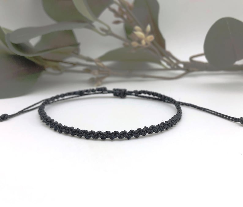 A black braided anklet made with strong waterproof fine cord.  Easy to wear as it is fully adjustable.  Pop it over your ankle and use the sliding woven knot to adjust to fit. A perfect accessory for those who love surfing and the beach.