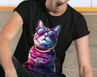 May include: Black t-shirt featuring a vibrant graphic of a cat wearing sunglasses. The cat's fur is a mix of pink, purple, and blue hues, with a yellow collar. The sunglasses have a colorful, reflective lens design. The shirt is a classic crew neck.