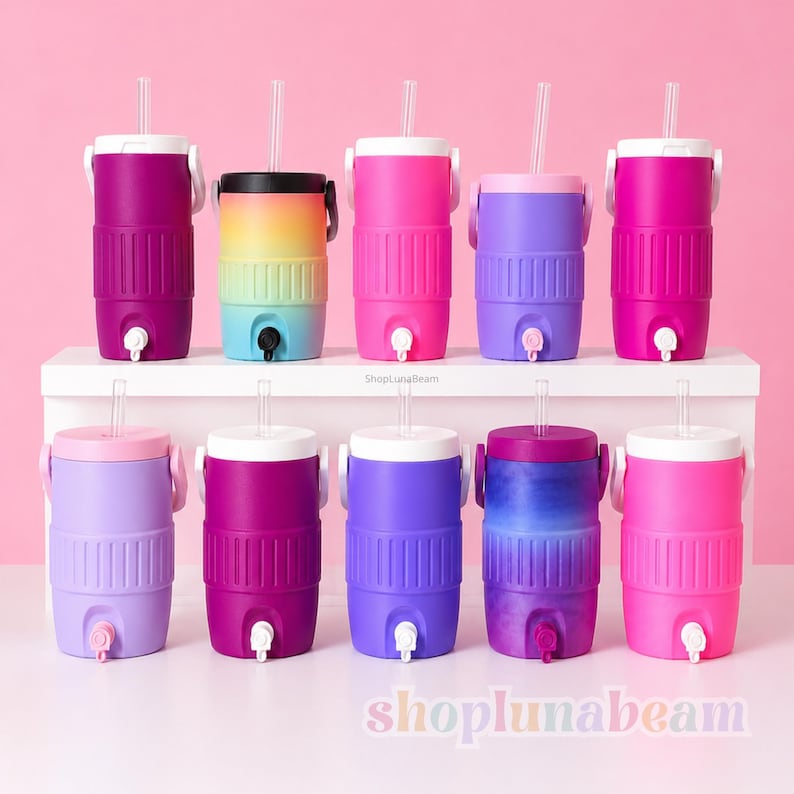 May include: A selection of brightly coloured insulated water coolers with straws. The coolers are available in shades of pink, purple, and a rainbow gradient. Each cooler has a white lid, a handle, and a tap for dispensing liquids.
