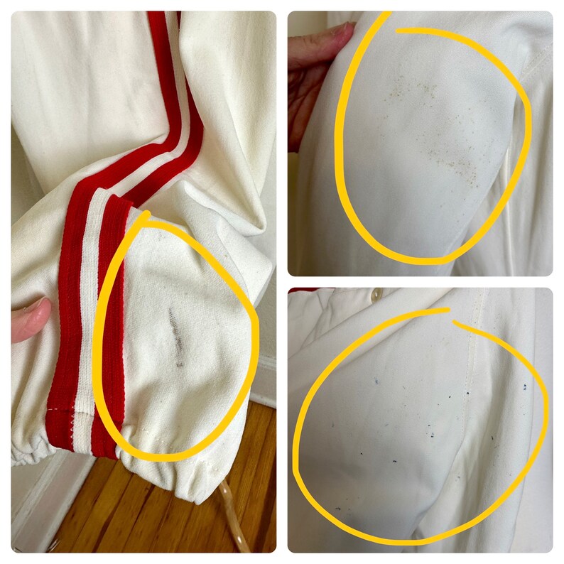 May include: Cream-colored athletic jacket with red and white stripes down the sleeves. The jacket has a ribbed cuff and a drawstring hem. There are some stains on the jacket.