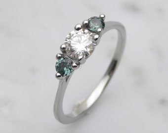 Anillo de compromiso de tres piedras con moissanita genuina y zafiro verde en oro blanco o titanio. Anillo de compromiso hecho a mano.