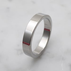 May include: A simple silver band ring with a polished finish.