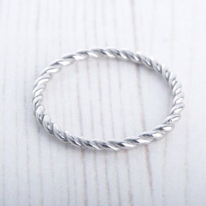 Puede incluir: Un anillo de banda torcido de plata.