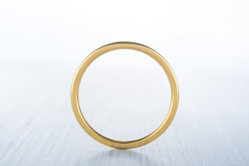 May include: A simple gold band ring.