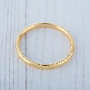May include: A simple gold band ring, a classic and timeless design.