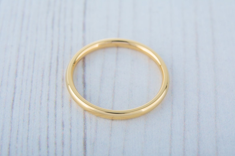 May include: A simple gold band ring, a classic and timeless design.