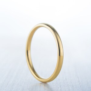 May include: A simple gold wedding band with a smooth, polished finish.