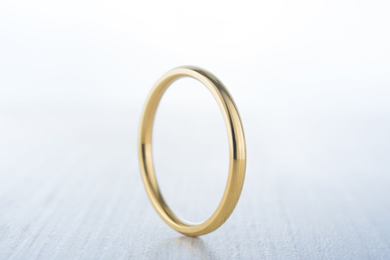 May include: A simple gold wedding band with a smooth, polished finish.