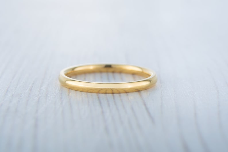May include: A simple gold wedding band with a smooth, polished finish.