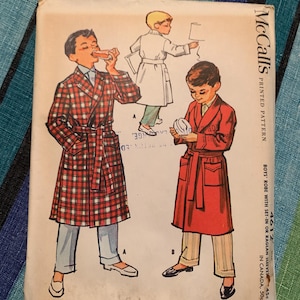 Op de afbeelding: Vintage McCall's naaipatroon voor jongensbadjassen. De patroonhoes toont illustraties van jongens die badjassen in verschillende stijlen dragen. Het patroonnummer is 4612. De prijs is 45 cent in de VS en 50 cent in Canada.